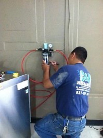 A C&N Mechanical technician on a commercial job in a company shirt